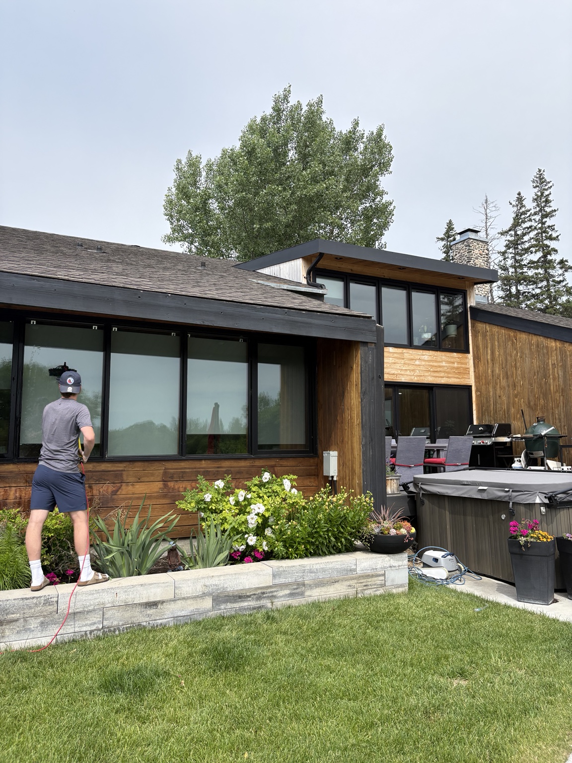 Newmar technician cleaning windows at a modern home